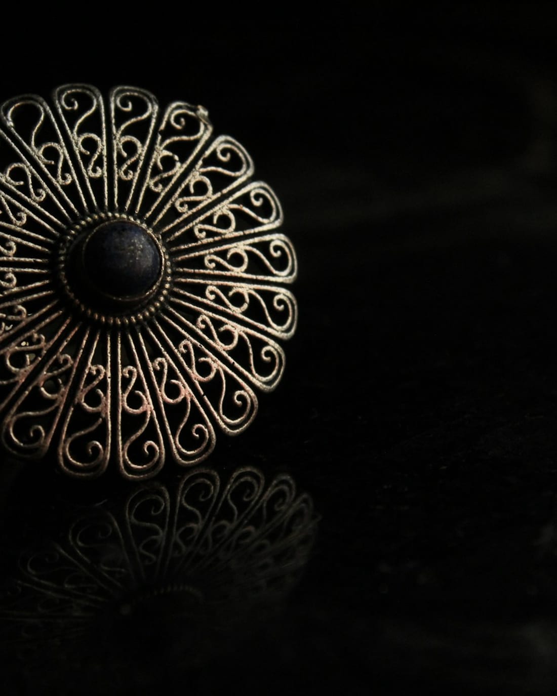 Silver filigree brooch with a dark centre stone